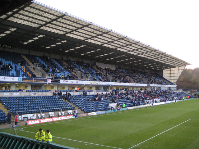The Woodlands Stand at Adams Park, Wycombe Wanderers, a small covered stand with wooded hills rising behind the ground